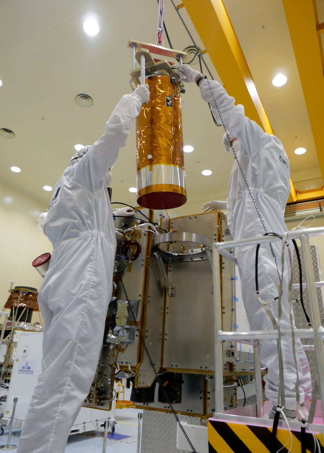 Image of KARI engineers preparing to guide ShadowCam into its mounting hardware on the KPLO satellite exterior.